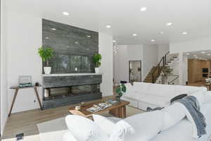 Living area featuring light wood finished floors, a multi sided fireplace, and recessed lighting