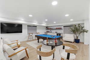 Game room featuring billiards table, light wood finished floors, wet bar, and recessed lighting