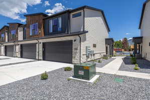Modern townhome exterior featuring stone veneer and vertical wood siding accents