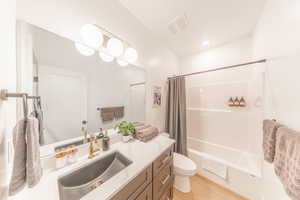 Full bathroom with vanity, shower / bath combo, and light wood-type flooring