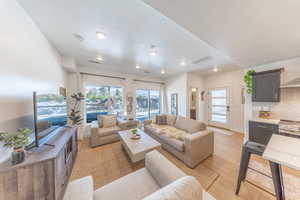 Large living space with sliding glass doors to patio with hot tub.