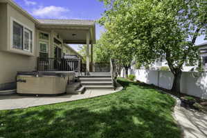 Fenced backyard with a wooden deck and a hot tub