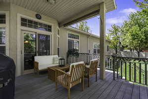Deck with an outdoor living space and area for grilling