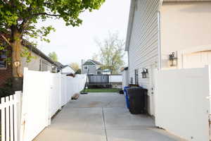 Fenced backyard with a trampoline and a patio