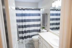 Bathroom featuring vanity, a shower with curtain, and light tile patterned floors