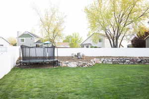 Fenced backyard with a trampoline