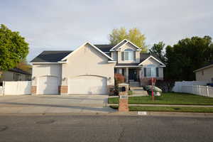 Traditional-style house with a garage, driveway, and stucco siding
