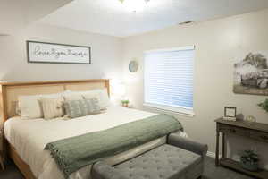 Bedroom with a textured ceiling and baseboards