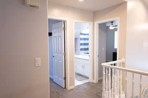 Corridor featuring an upstairs landing and baseboards