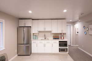 Kitchen featuring stainless steel appliances, white cabinetry, recessed lighting, and wood tiled floors