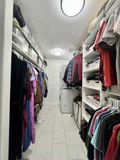Walk in closet featuring stacked washer / drying machine