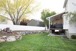 Fenced backyard with a ceiling fan, a patio area, and a wooden deck
