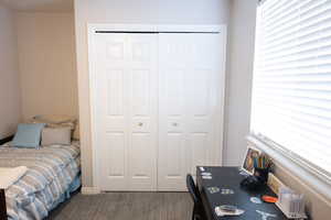 Bedroom featuring dark colored carpet, a closet, and multiple windows