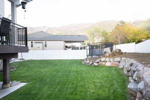 Fenced backyard featuring a trampoline and a mountain view