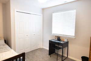 Bedroom with light colored carpet, a closet, and multiple windows