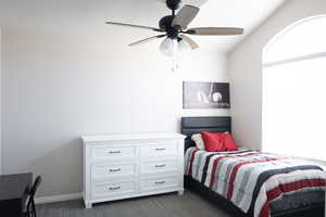 Bedroom with ceiling fan and dark carpet