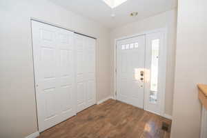 Entrance foyer with LVP flooring and a large coat closet. Above the entry is a skylight.