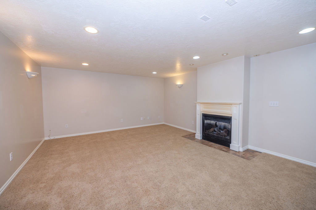 Living room with a fireplace and recessed lighting.