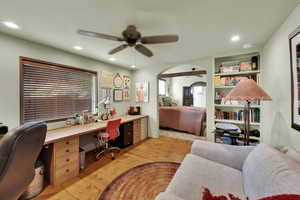 Office with light wood-style floors, a ceiling fan, recessed lighting, and built in shelves