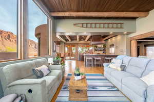 Living area featuring a wooden ceiling with exposed beams, light wood finished floors, and a mountain view