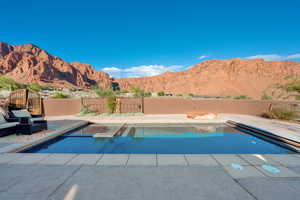 View of swimming pool with a fenced backyard, a mountain view, and patio surround