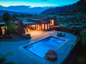 Rear view of property featuring a mountain view, a patio area, an outdoor pool, and an in-ground hot tub