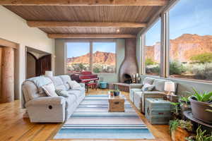 Living room featuring a mountain view, a wood ceiling with exposed beams, and light wood finished floors