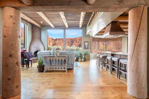 Bedroom with light wood-type flooring and a wood ceiling with exposed beams