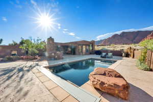 View of pool with patio surround, outdoor lounge area, a mountain view, and a fenced backyard