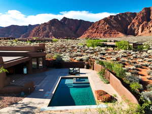 View of swimming pool with a mountain view, a fenced backyard, and patio surround