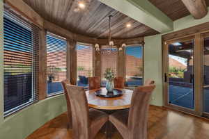 Dining area with a chandelier, wood ceiling, and wood finished floors