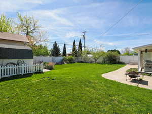 Fenced backyard with a patio and an outdoor fire pit