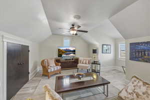 Living area with ceiling fan and baseboards