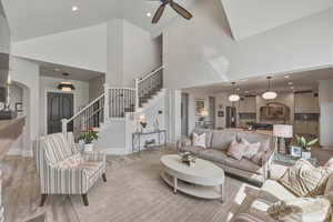 Living area featuring recessed lighting, light wood-style flooring, a ceiling fan, arched walkways, and vaulted ceiling