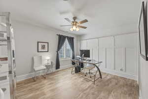 Home office featuring light wood-style flooring and ceiling fan