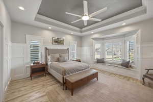 Bedroom with a decorative wall, multiple windows, a wainscoted wall, recessed lighting, and light wood-type flooring