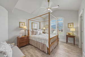 Bedroom with lofted ceiling, light wood-style flooring, and a ceiling fan