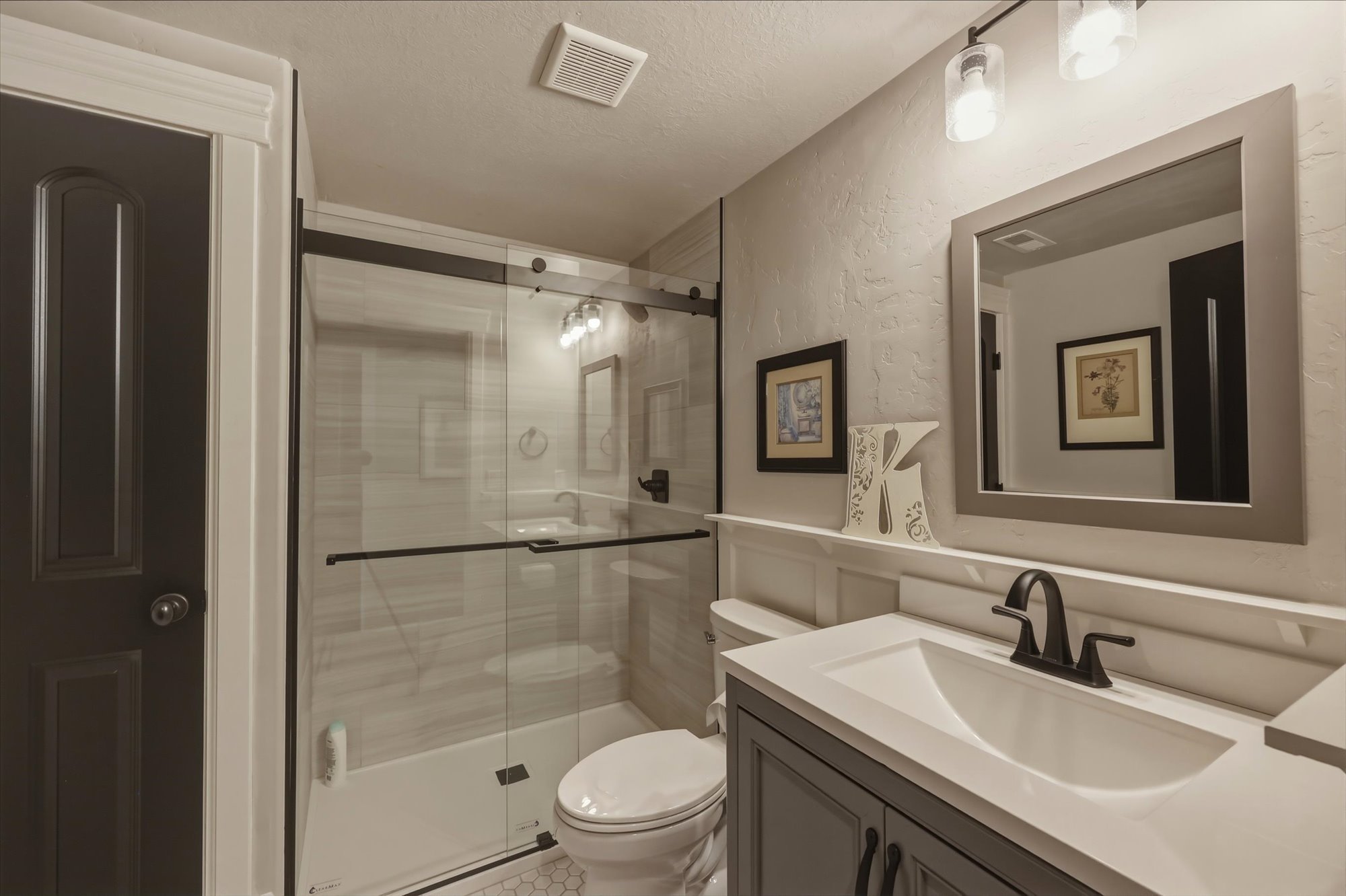 Bathroom featuring vanity, a stall shower, and a textured wall