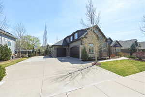 View of side of home with stone siding, driveway, and a garage
