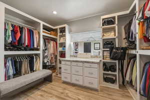 Walk in closet with light wood-type flooring