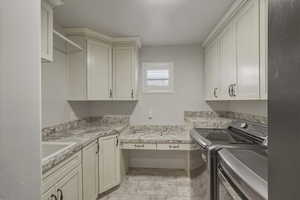 Laundry room with separate washer and dryer and cabinet space