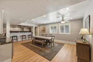 Dining area featuring light wood-style flooring, ceiling fan, recessed lighting, and a textured ceiling