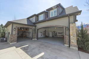View of front facade featuring concrete driveway and roof with shingles