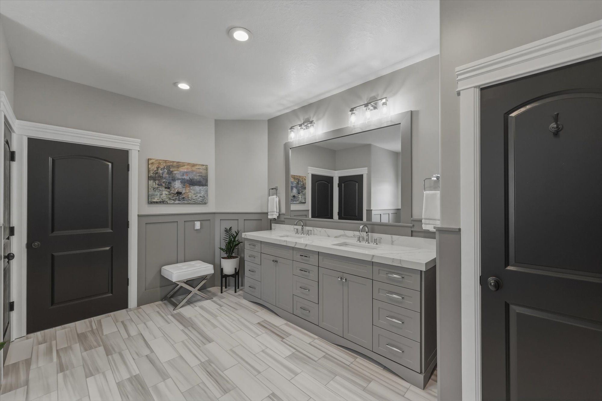 Bathroom with a decorative wall, double vanity, a wainscoted wall, and recessed lighting