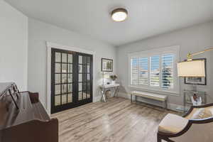 Sitting room featuring french doors and light wood-style floors