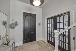 Entryway featuring french doors and light wood-style floors