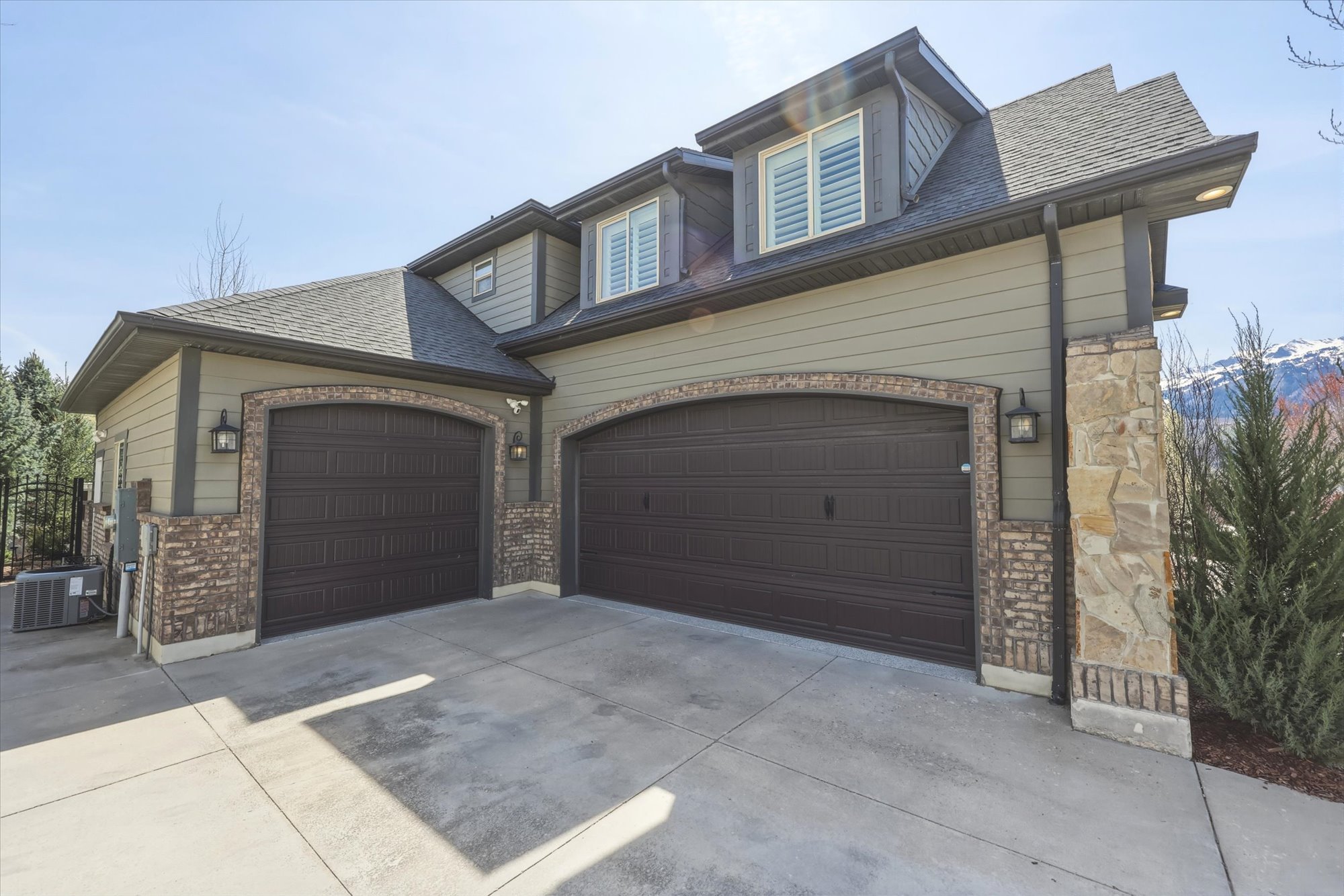 View of front of house with driveway, a shingled roof, and a garage