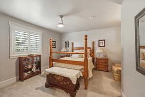 Bedroom with ceiling fan and light colored carpet