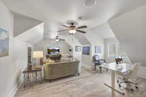 Bedroom featuring an office area, lofted ceiling, light wood-style flooring, and ceiling fan