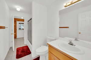 Full bathroom with a shower stall, vanity, and light tile patterned floors
